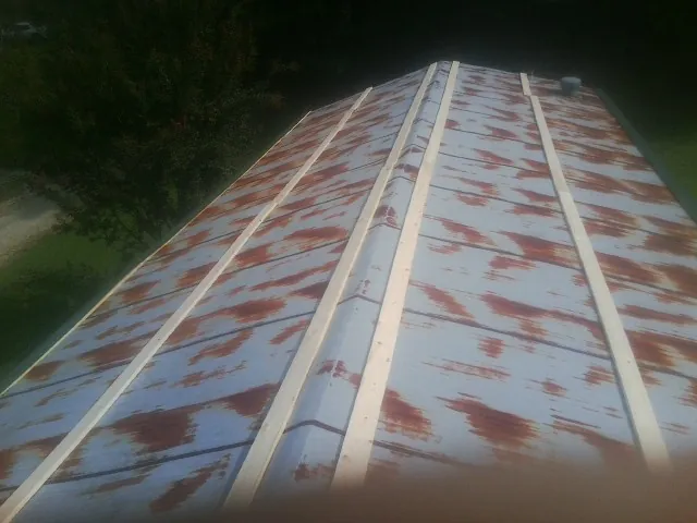 Rusted metal roof panels with new wood purlins before replacement — Storm Damage Roof Repair in East Jewett by Roofing Brothers