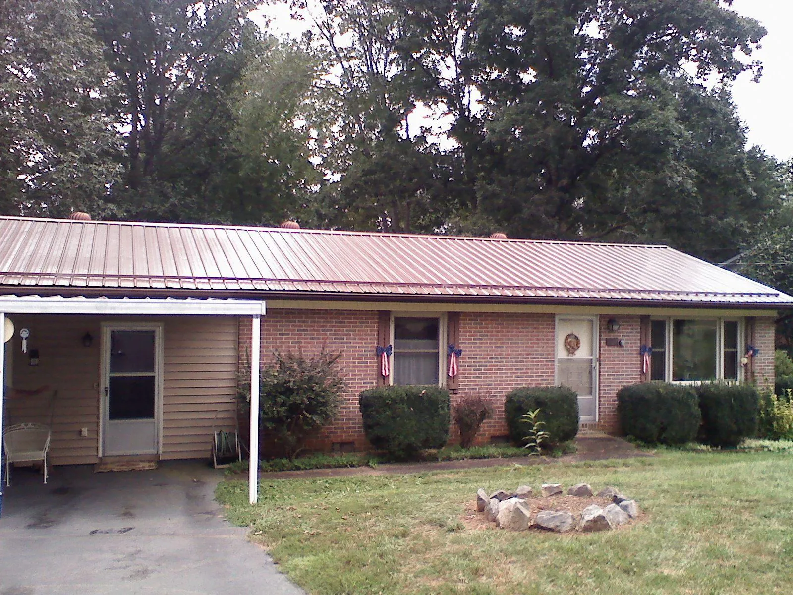 Bronze metal roof and carport on a brick ranch home — Roof Repair work by our crew in East Jewett